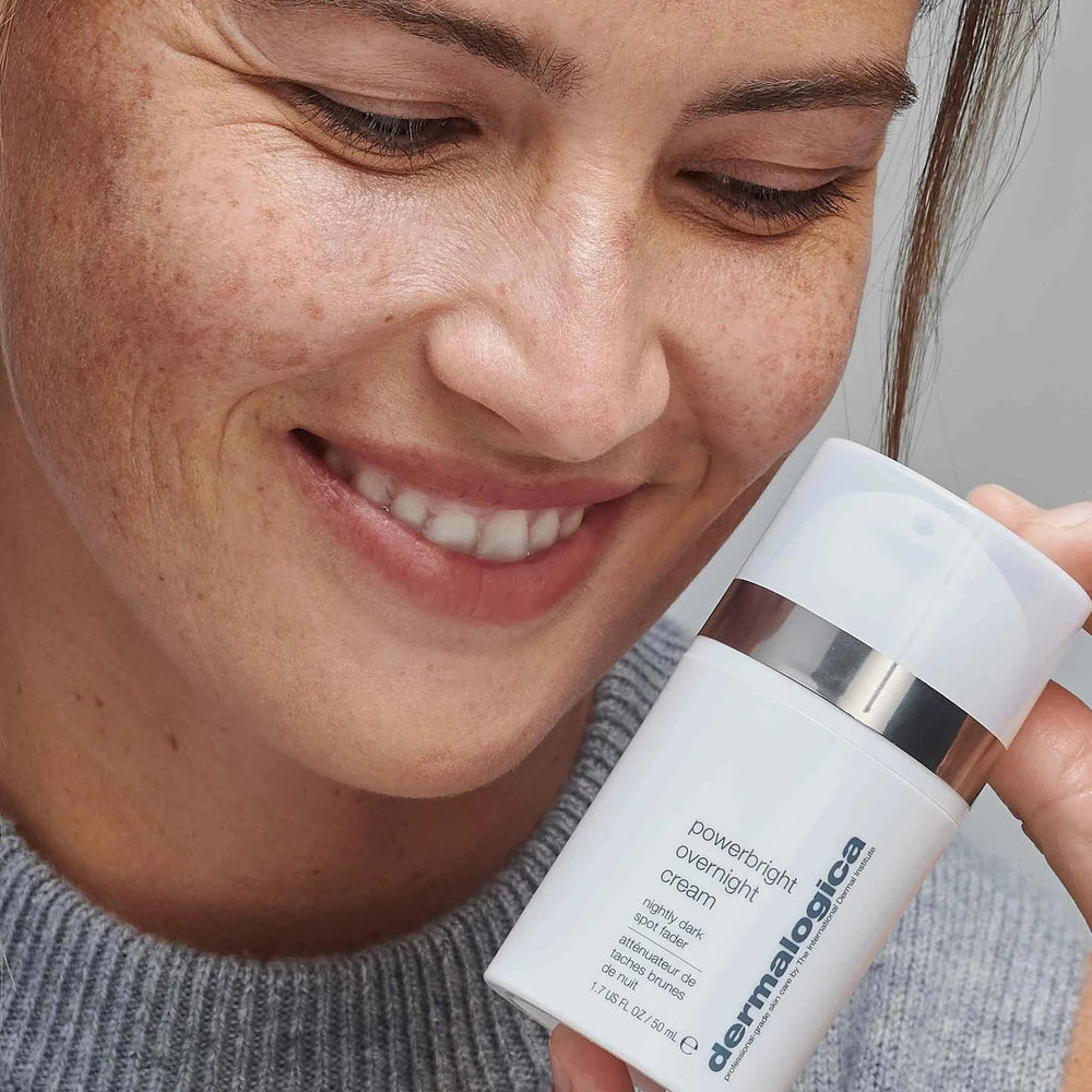 Woman holding a Dermalogica powerbright overnight cream bottle.
